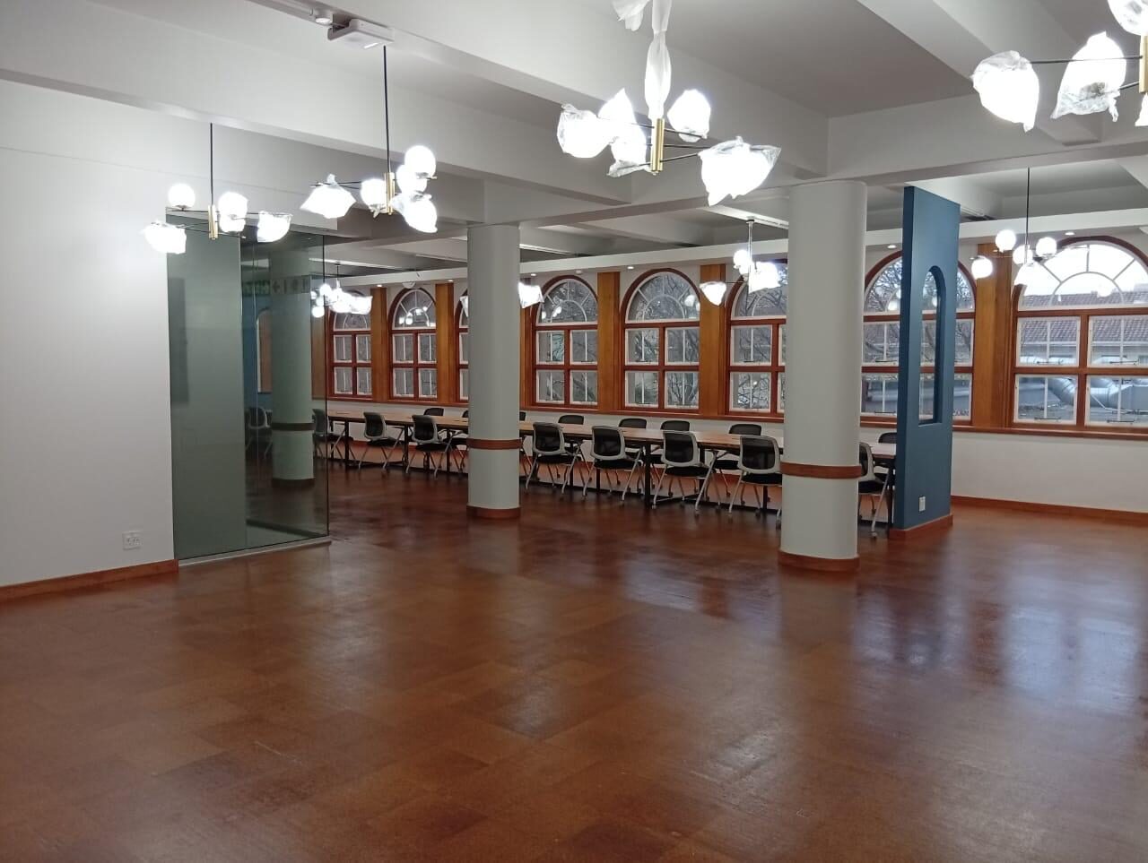 Completed heritage interior refurbishment by Revo Projects — arched sash windows, feature chandeliers, glass partitioning and a polished timber floor