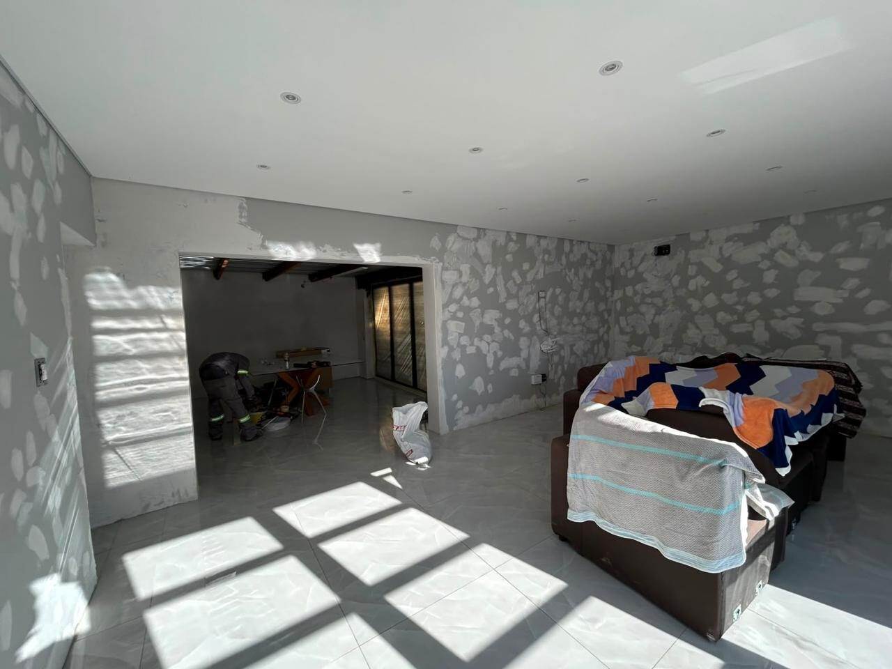 Open-plan living area during the renovation, floors newly tiled