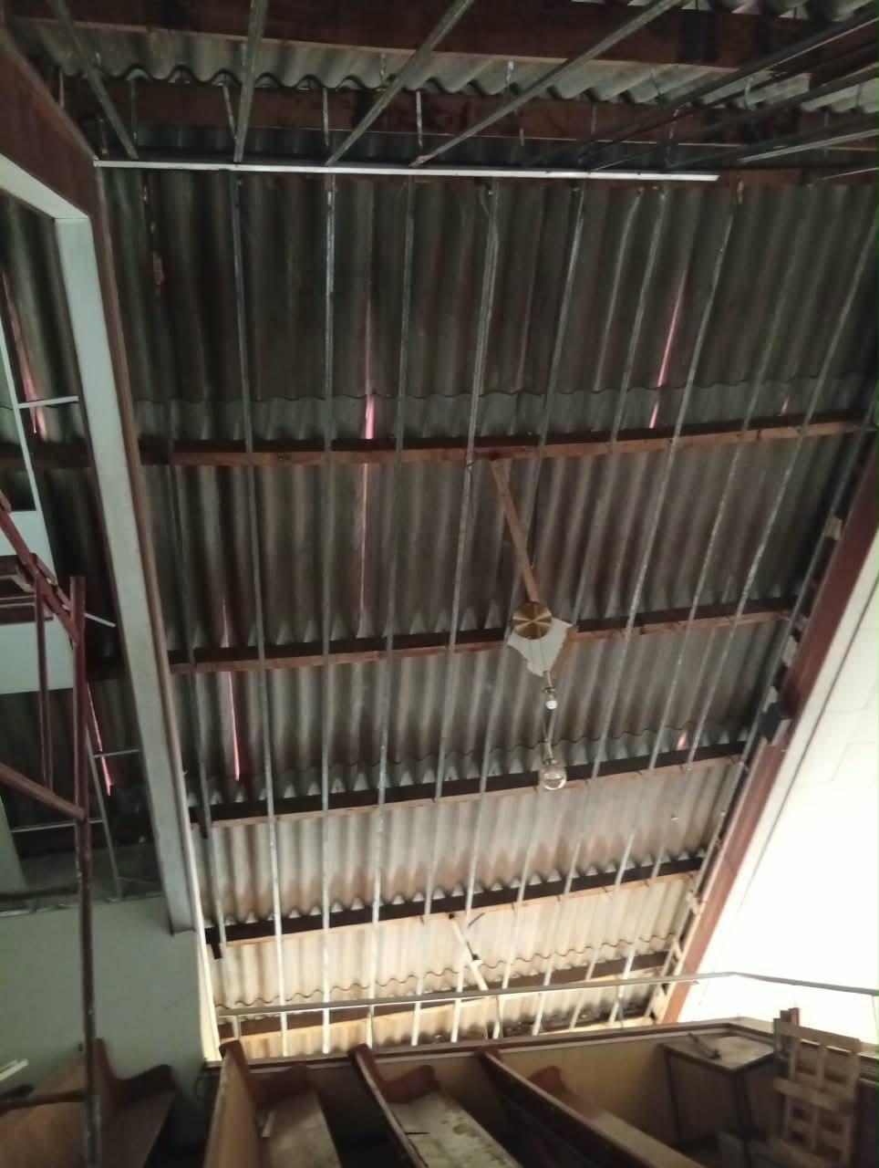 The original ceiling stripped out, exposing the corrugated roof sheeting, timber purlins and the new suspension grid